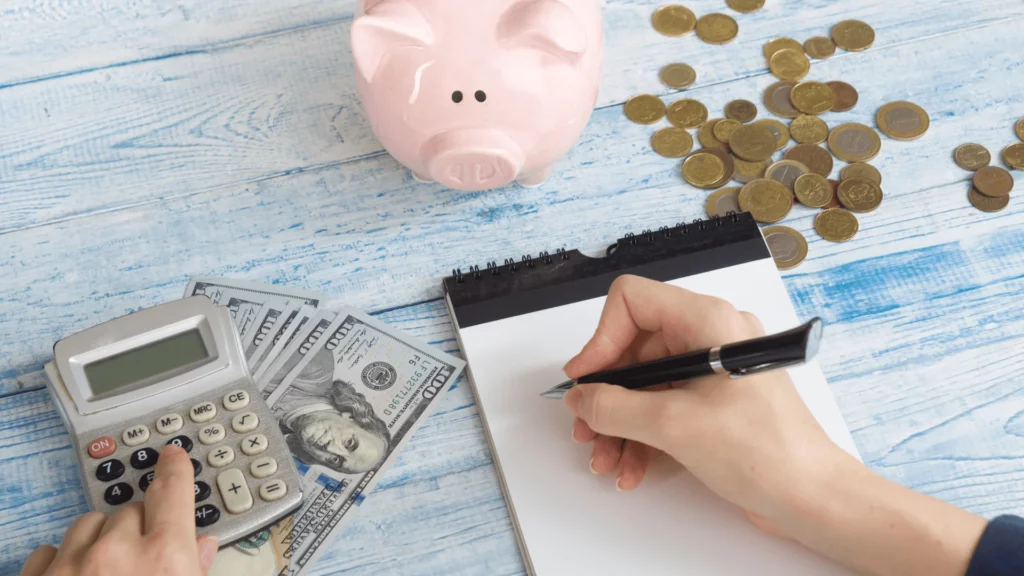 Personne écrivant avec de la monnaie éparpillée autour